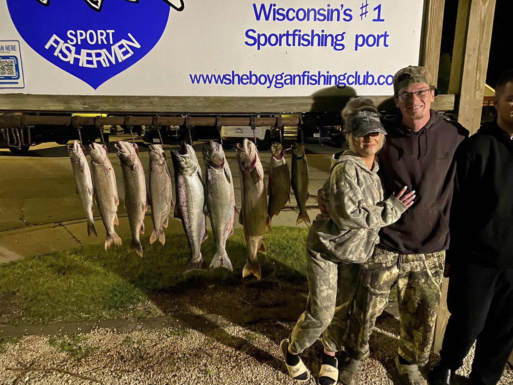 Successful salmon and lake trout fishing trip in Sheboygan Wisconsin with multiple fish displayed at cleaning station