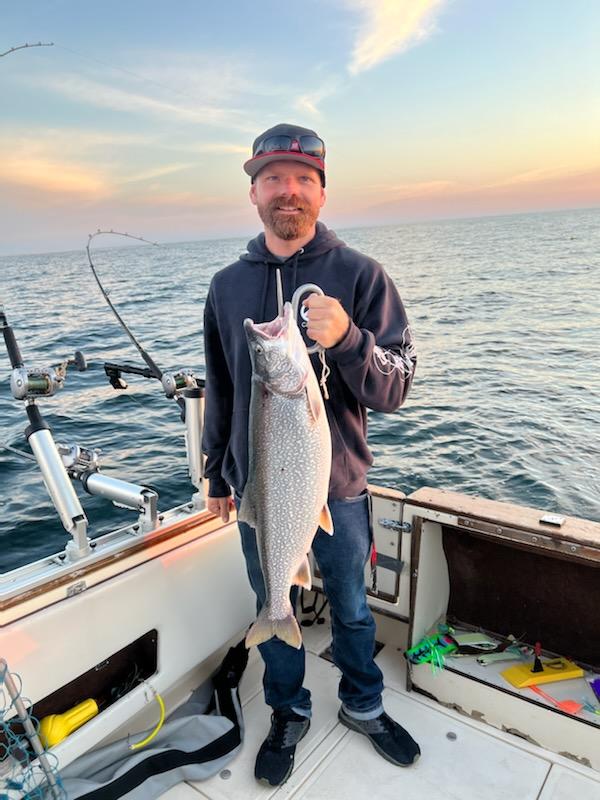 Angler holding a large lake trout in Manistee