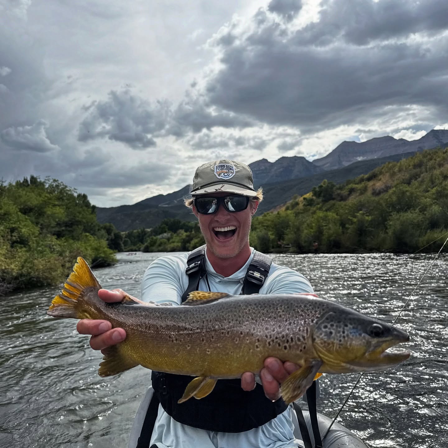 Brown trout caught while fishing in Park City UT with mountains and river in background