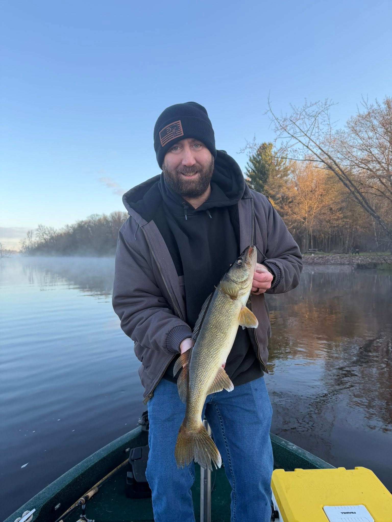 Walleye caught while fishing in Fort Atkinson WI on calm water with autumn trees in background