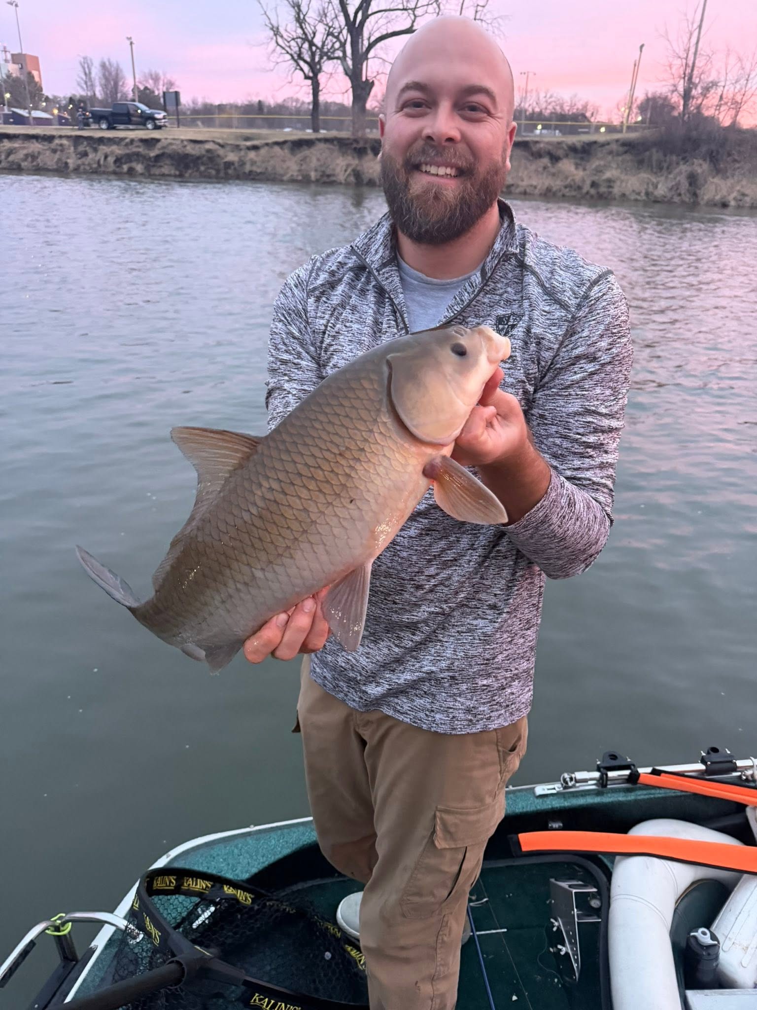 Angler holding caught smallmouth buffalo fish on boat in Fort Atkinson WI