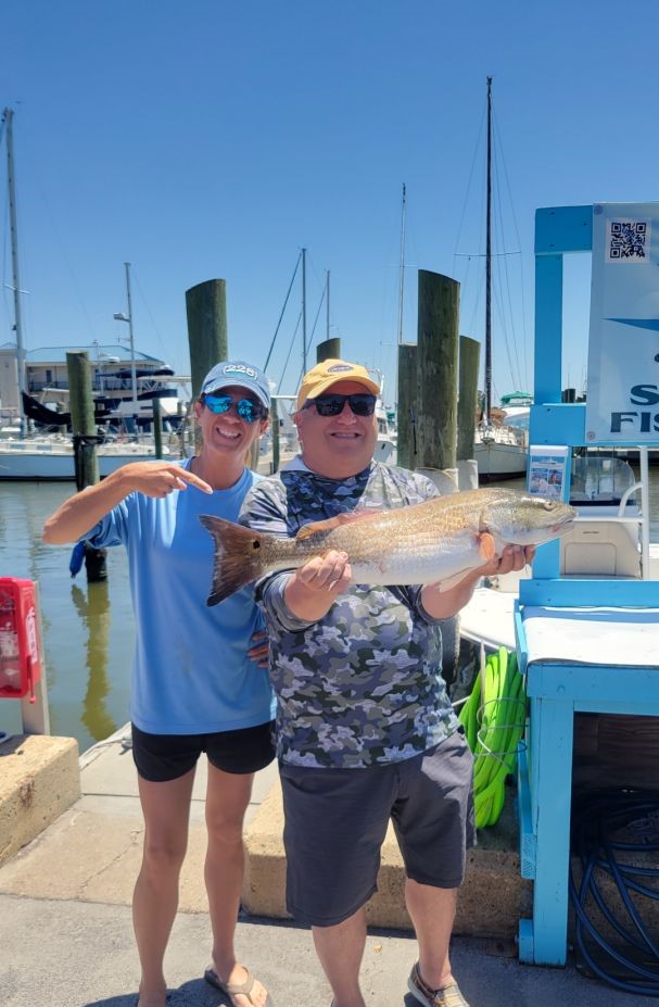 Two people fishing in Biloxi with a 28-inch catch