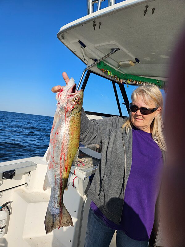 Angler holding freshly caught fish on fishing boat in Erie PA waters