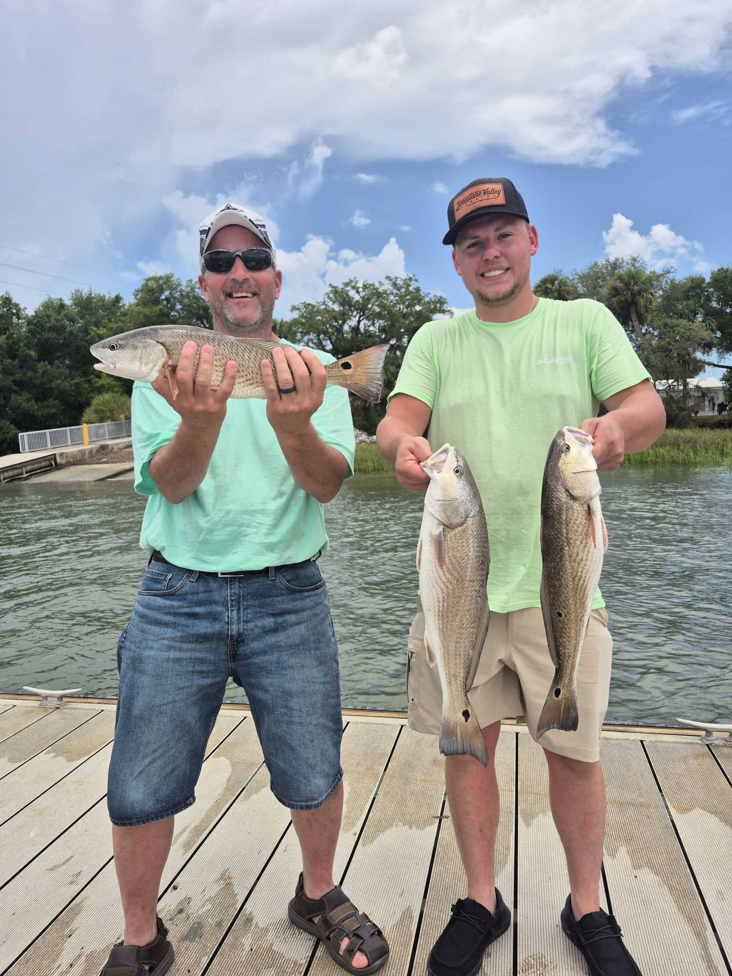 Three redfish caught during fishing trip at Hilton Head Island SC displayed on wooden dock