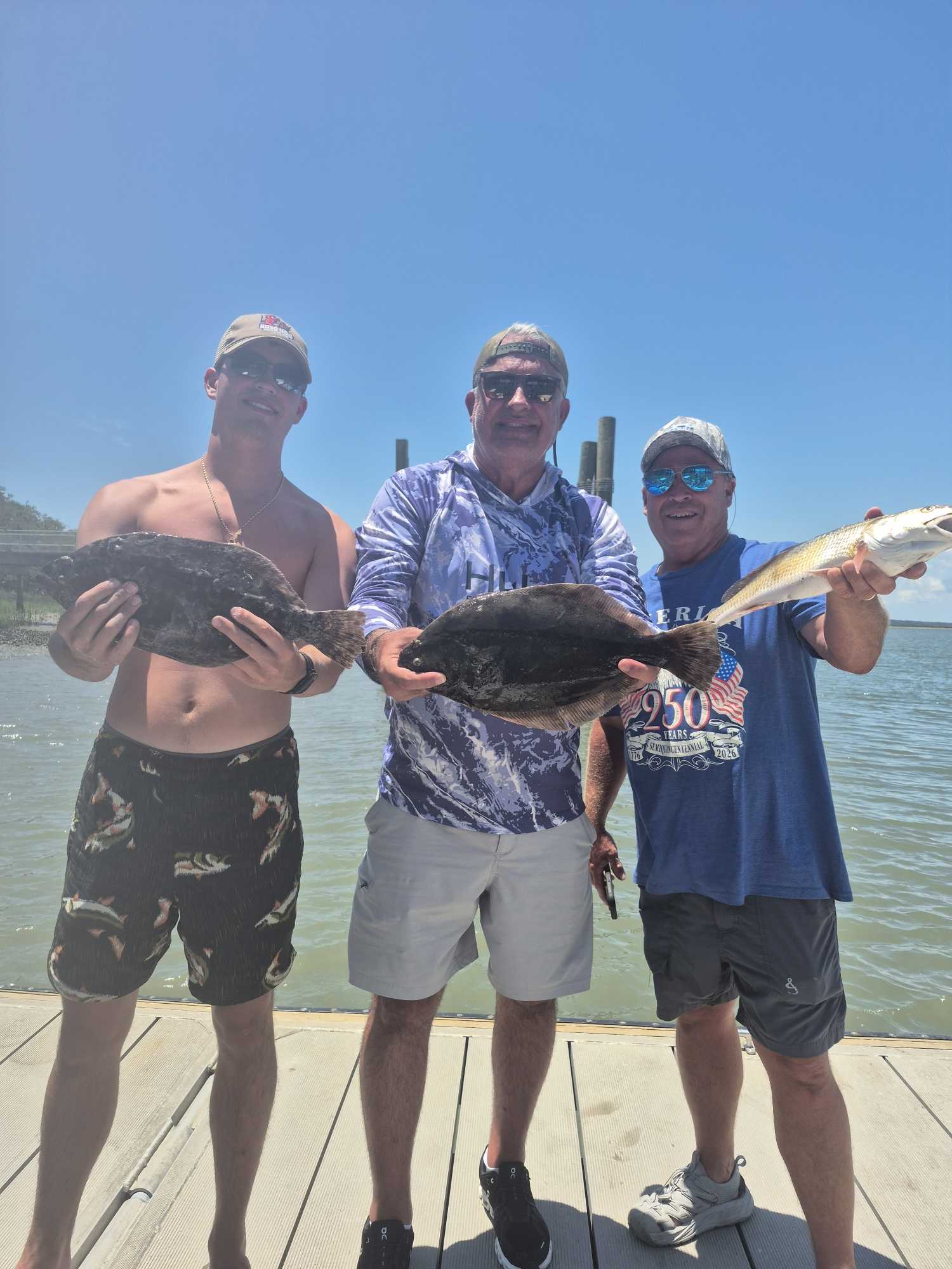 Three anglers displaying freshly caught Southern Flounder on wooden dock at Hilton Head Island SC