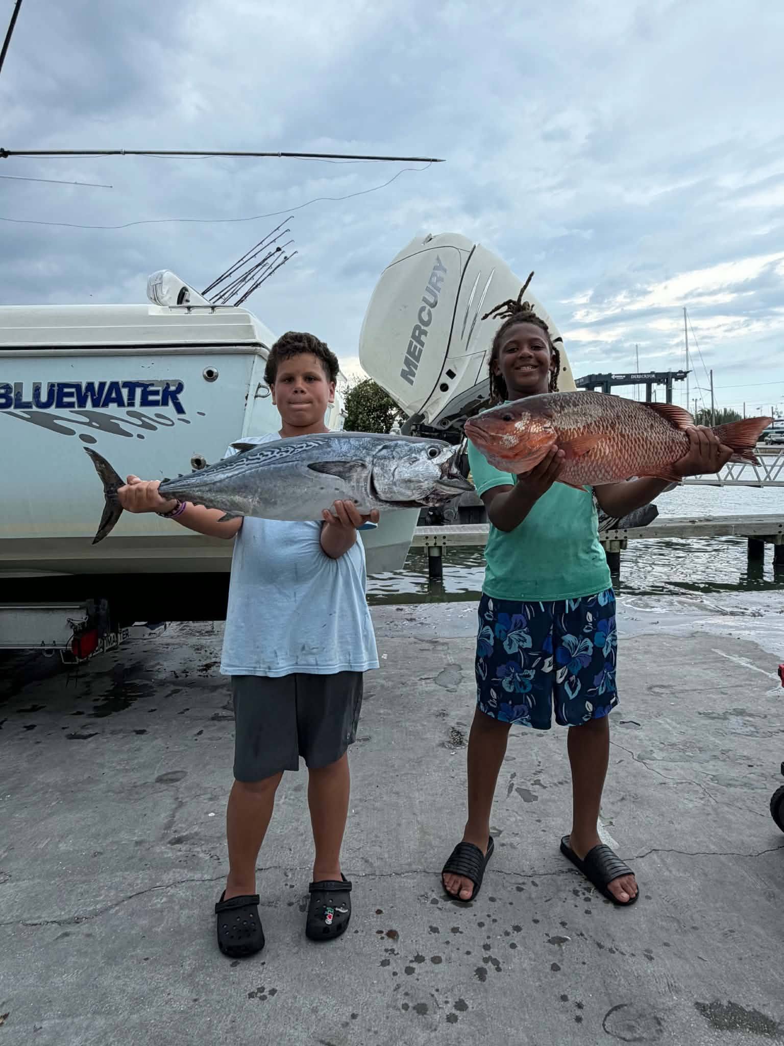 Two anglers displaying their catch of Little Tunny and snapper after fishing trip in Fort Pierce FL