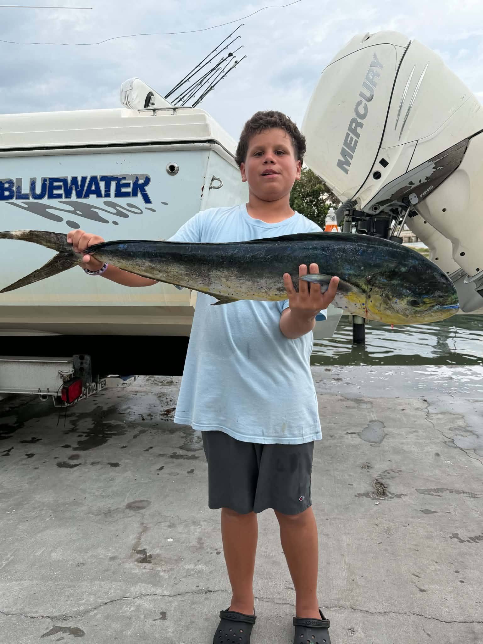 Mahi mahi catch displayed at Fort Pierce FL fishing dock with boat in background
