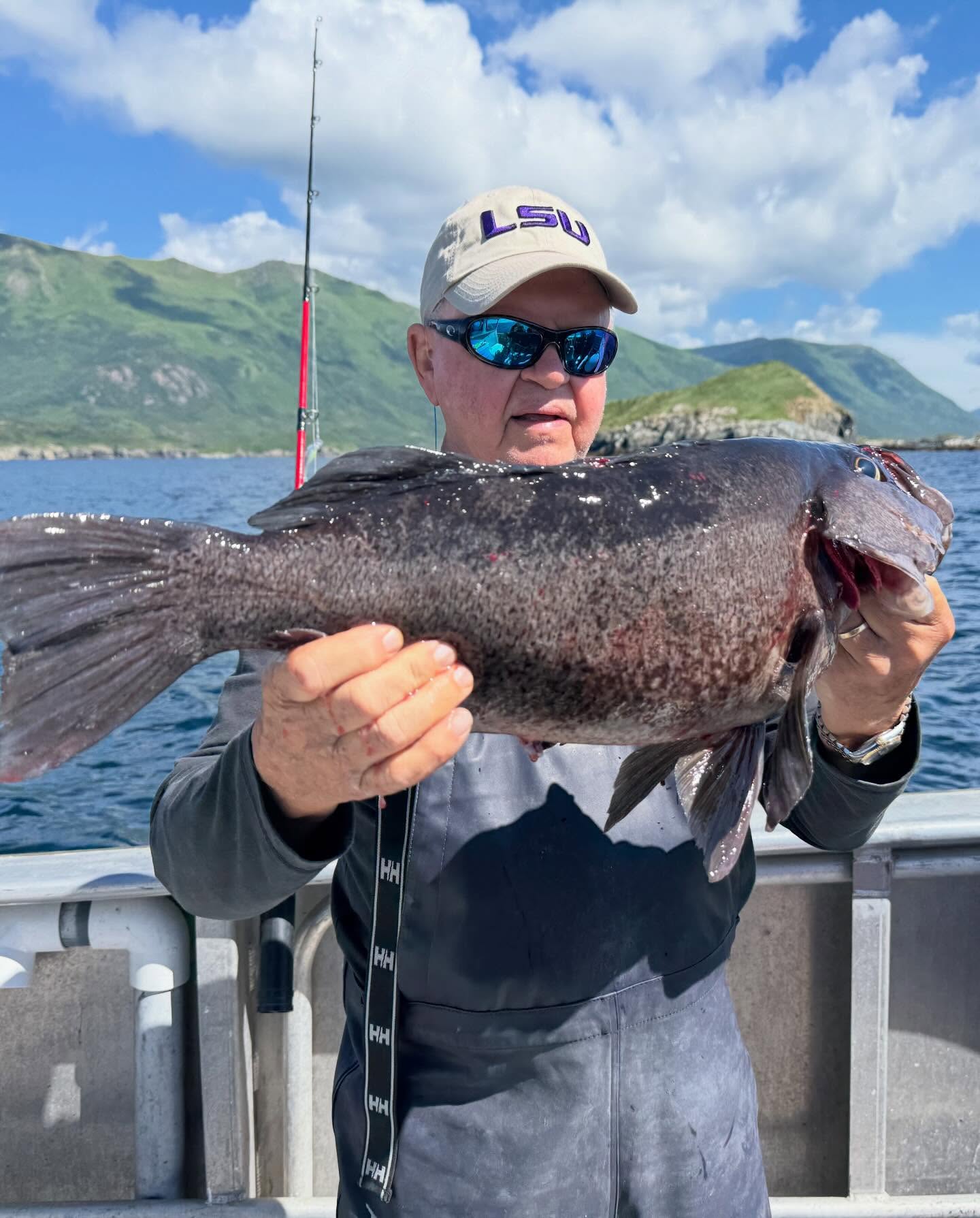 Large fish caught during fishing trip in Larsen Bay Alaska with mountains and water in background