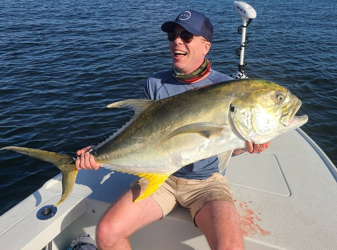 A fisherman holds a large Crevalle Jack fish in Boca Raton
