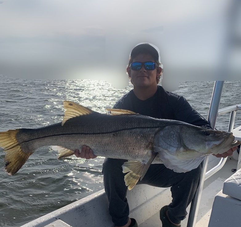 Angler holds a large snook fish caught in FL
