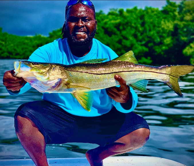 A large snook being held by a person in Punta Gorda