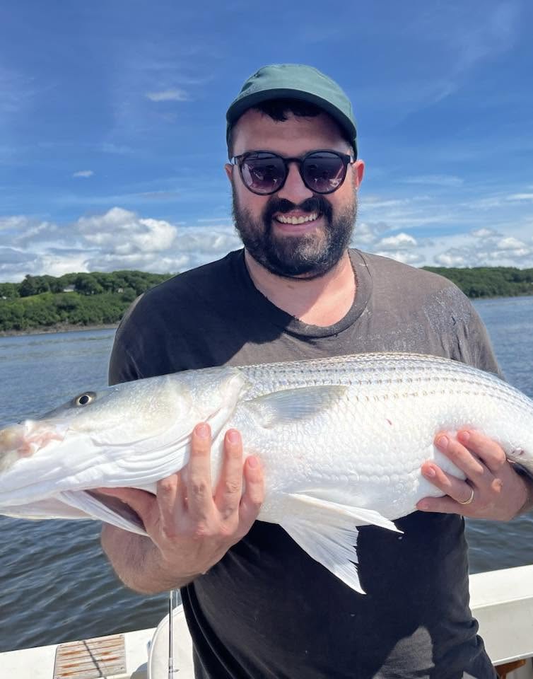 Angler holding caught fish on boat in Accord NY waters