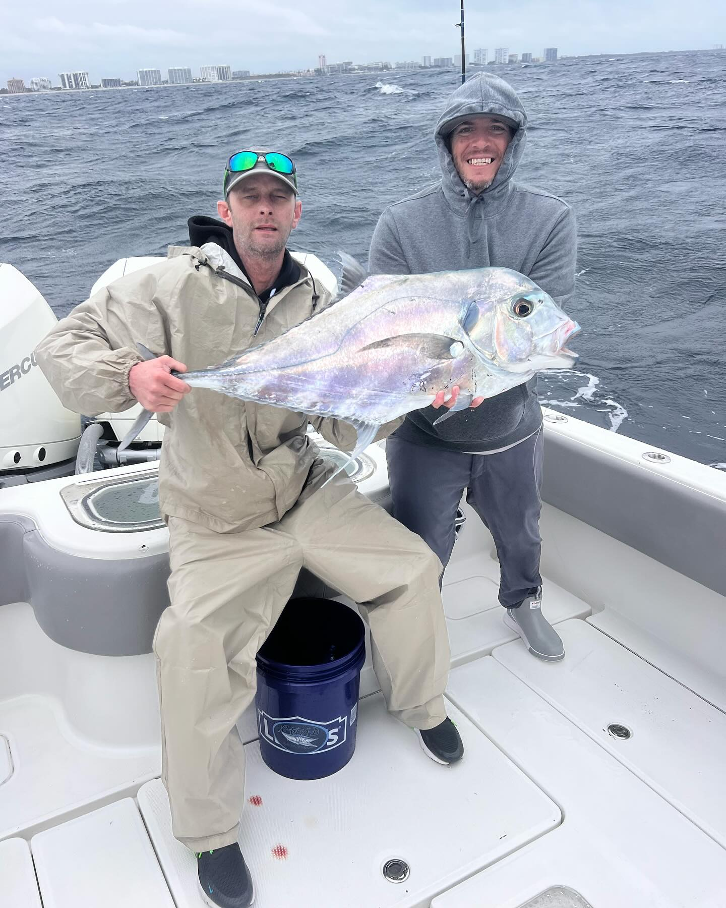 Angler holding a large African Pompano fish at Pompano Beach