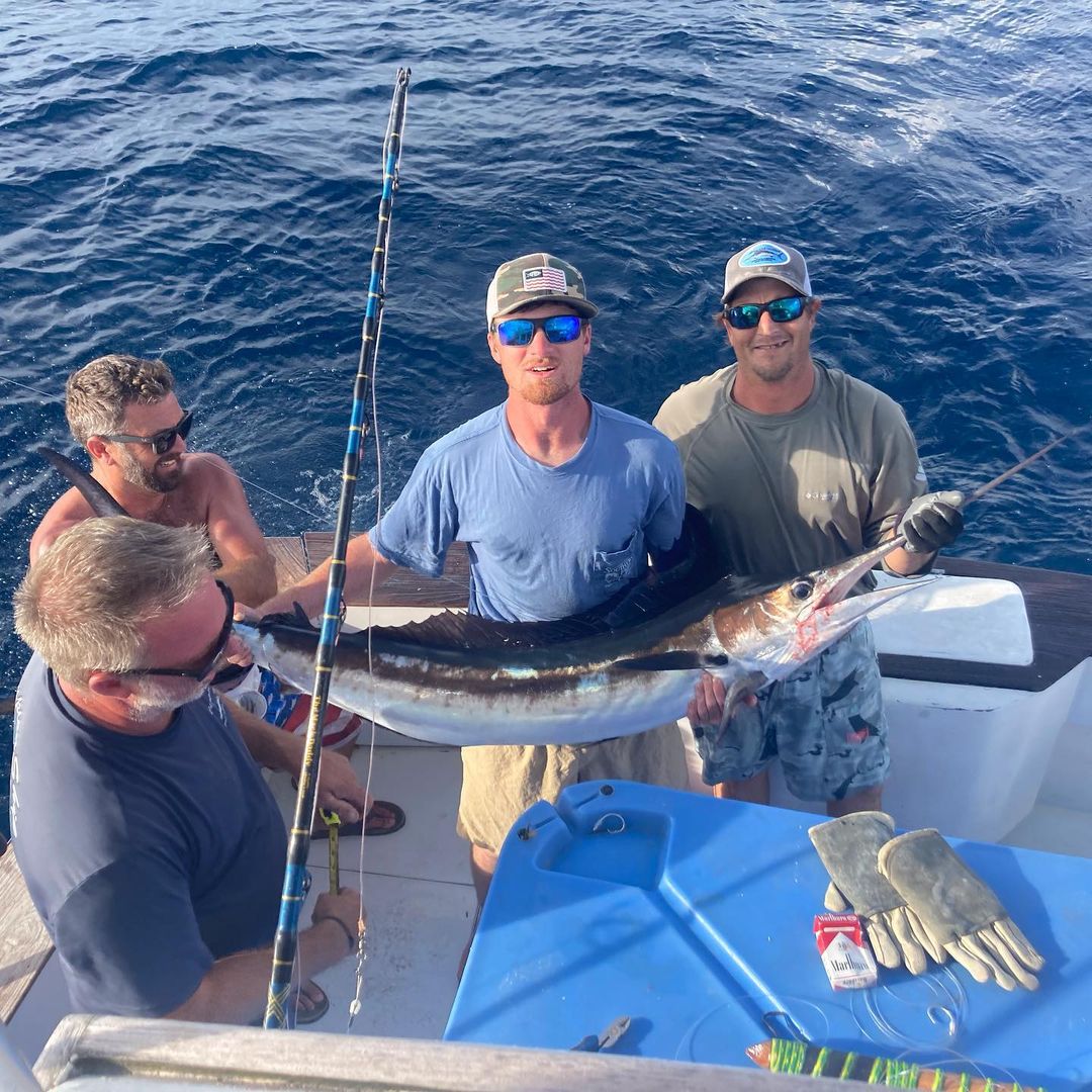 Three people fishing in Destin with a single, unspecified fish