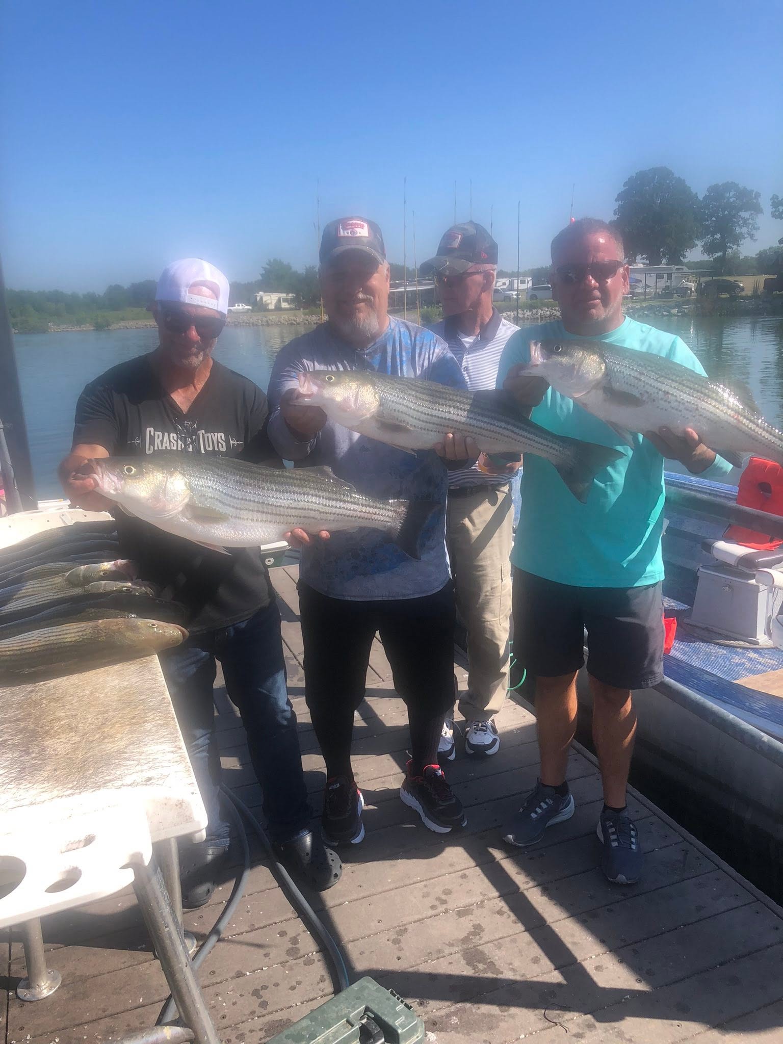 Three striped bass caught during fishing trip in Kingston OK displayed on boat deck