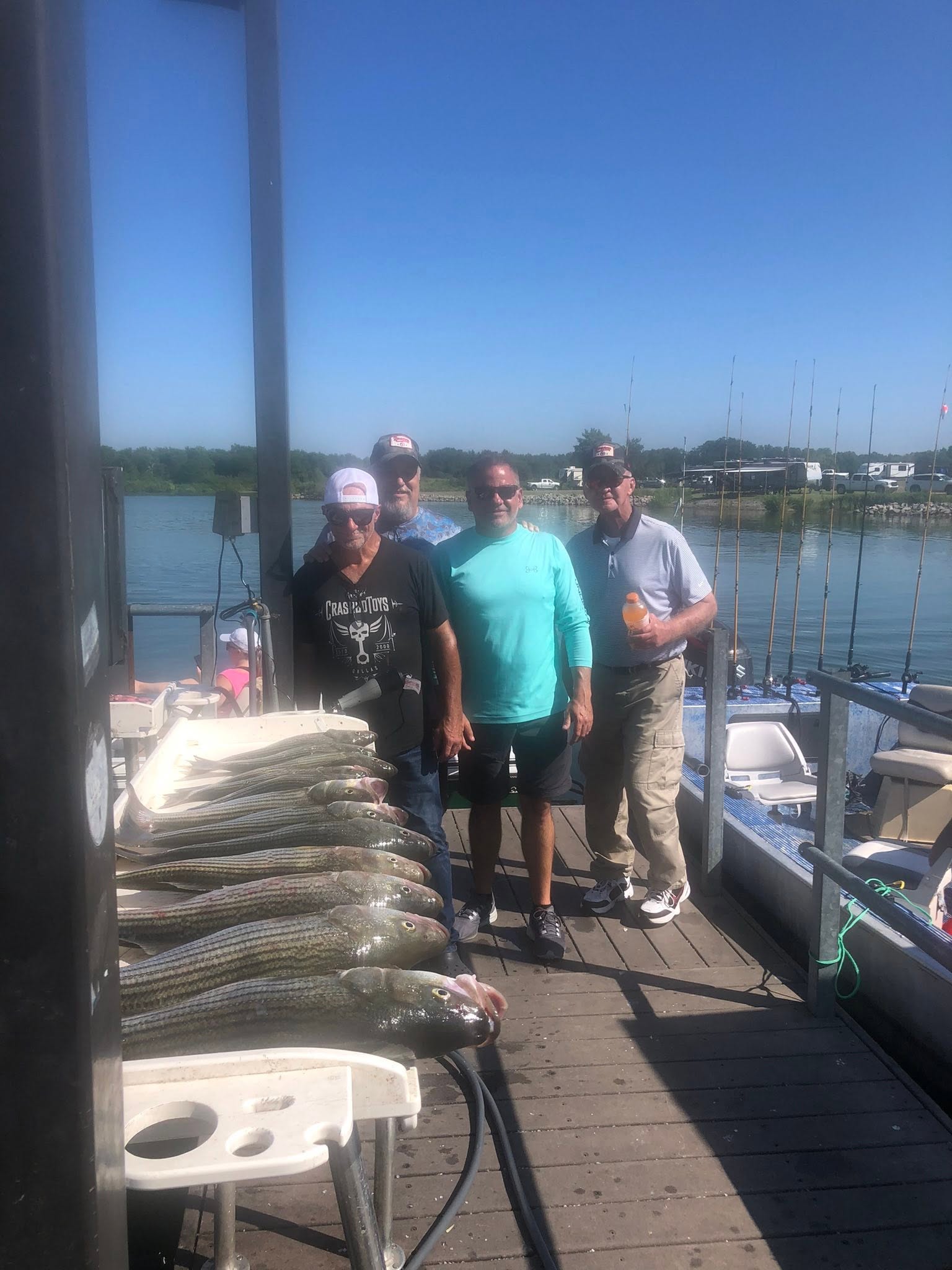 Successful striped bass fishing trip in Kingston OK with large catch displayed on dock