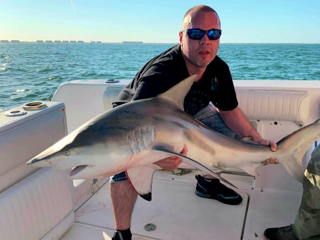 New Smyrna Beach shark fishing boat trip with anglers using heavy tackle for inshore saltwater fishing