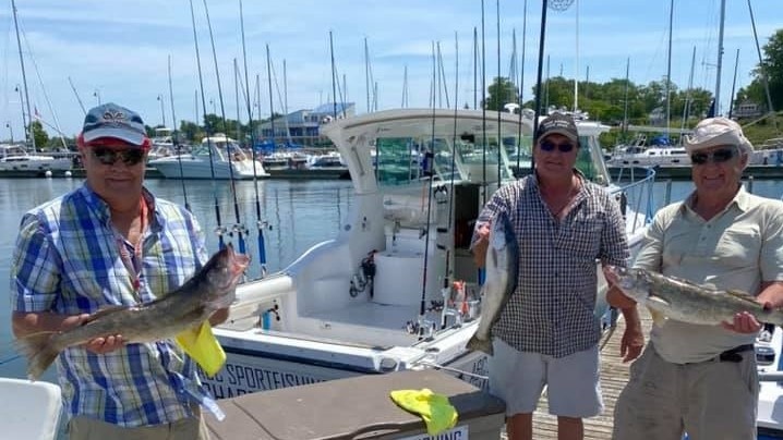 Three anglers holding three fish in Lorain