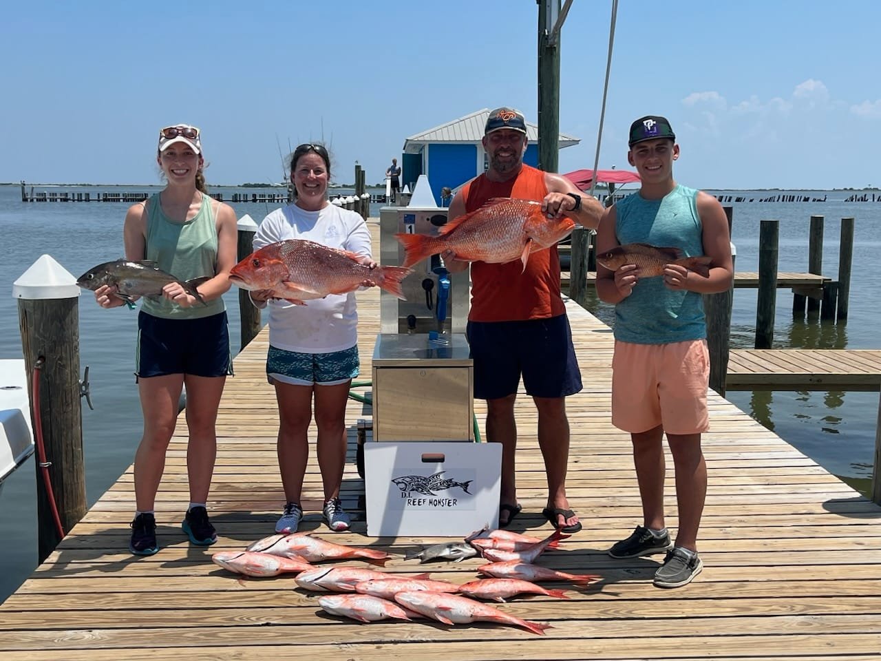 Four people fishing with large fish on Dauphin Island