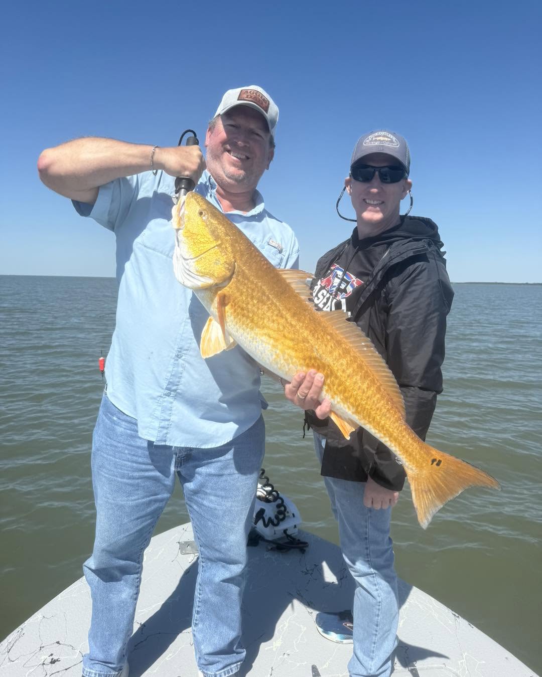 Two anglers displaying a large redfish caught on Bolivar Peninsula TX