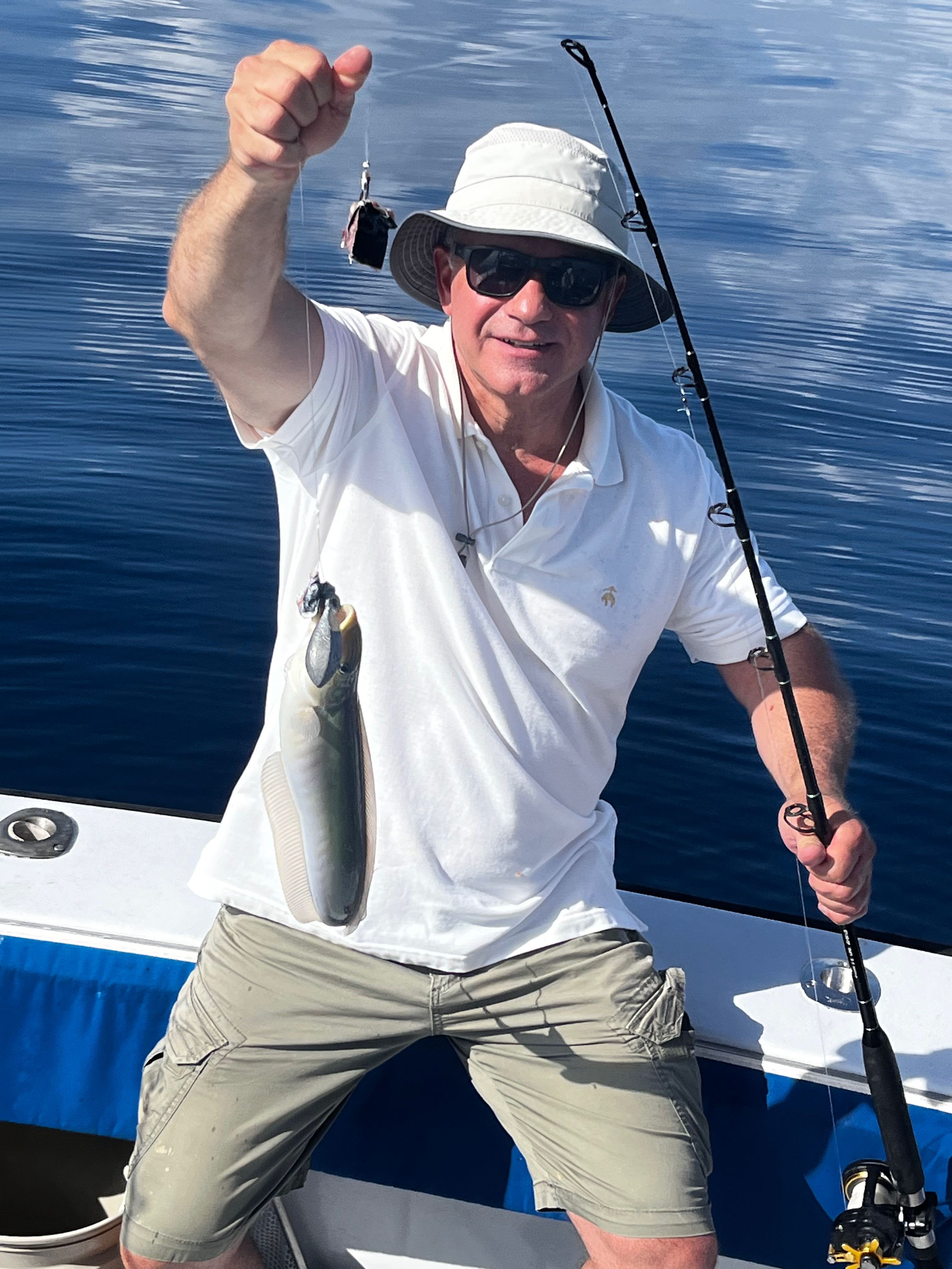 Angler holding caught fish on fishing boat in Riviera Beach FL waters
