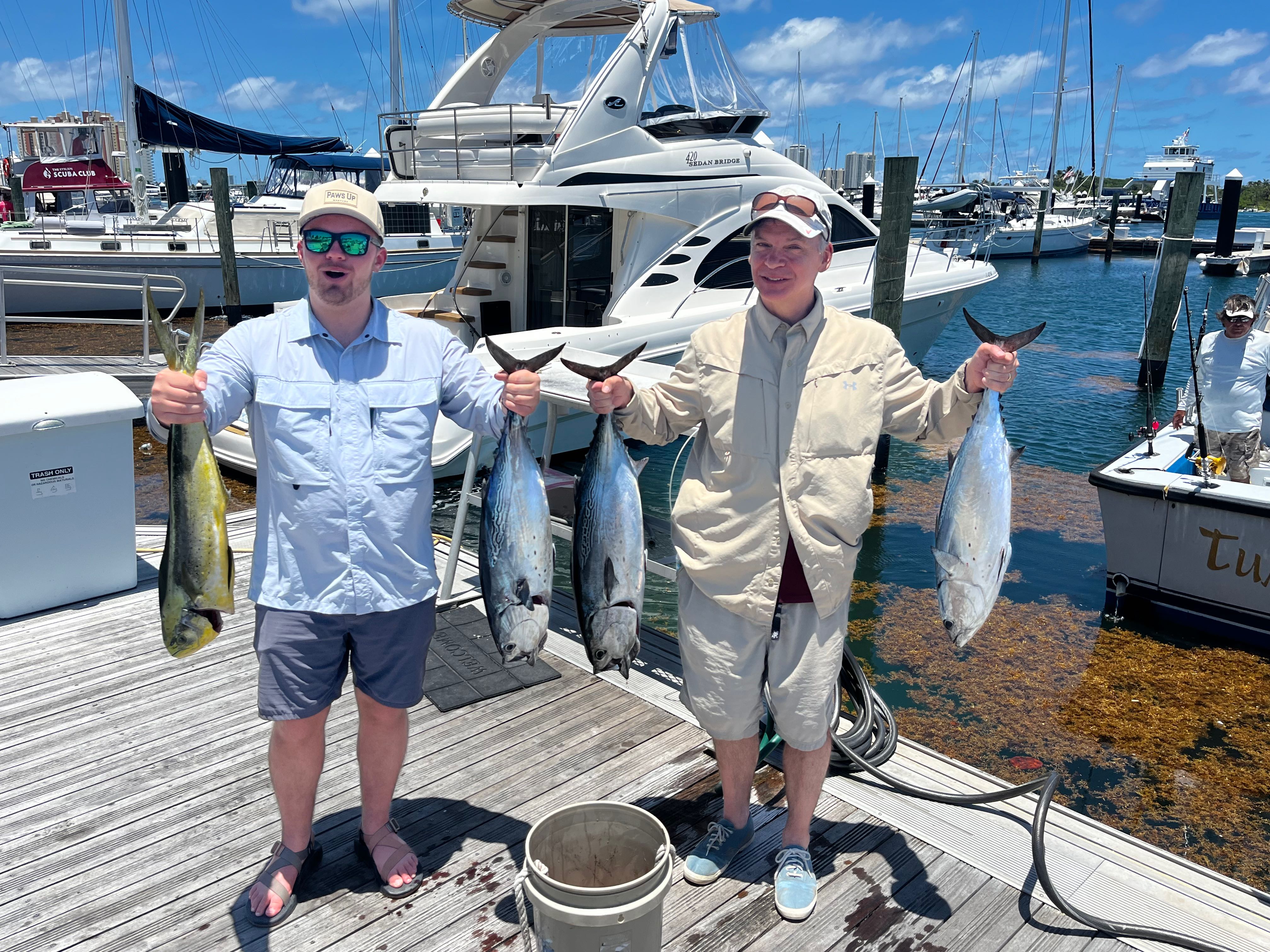 Successful fishing trip in Riviera Beach FL showing caught Little Tunny and Mahi Mahi at marina dock