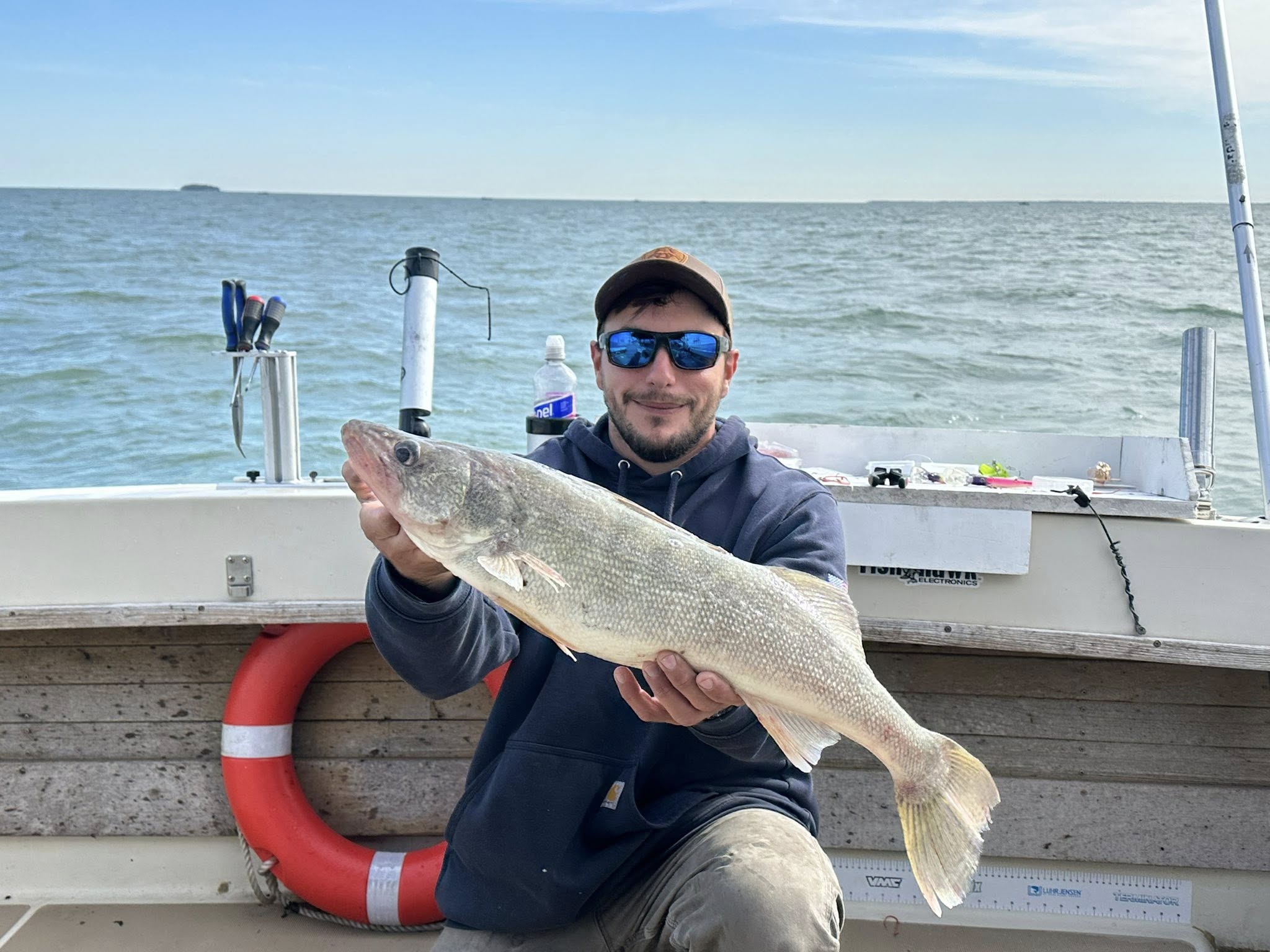 Angler holding large walleye fish on fishing boat in Mexico NY waters