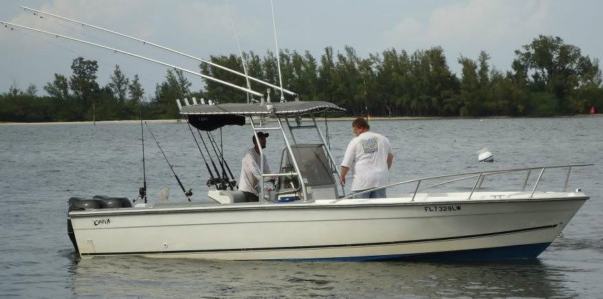 White center console fishing boat with outriggers on water near Sebastian FL