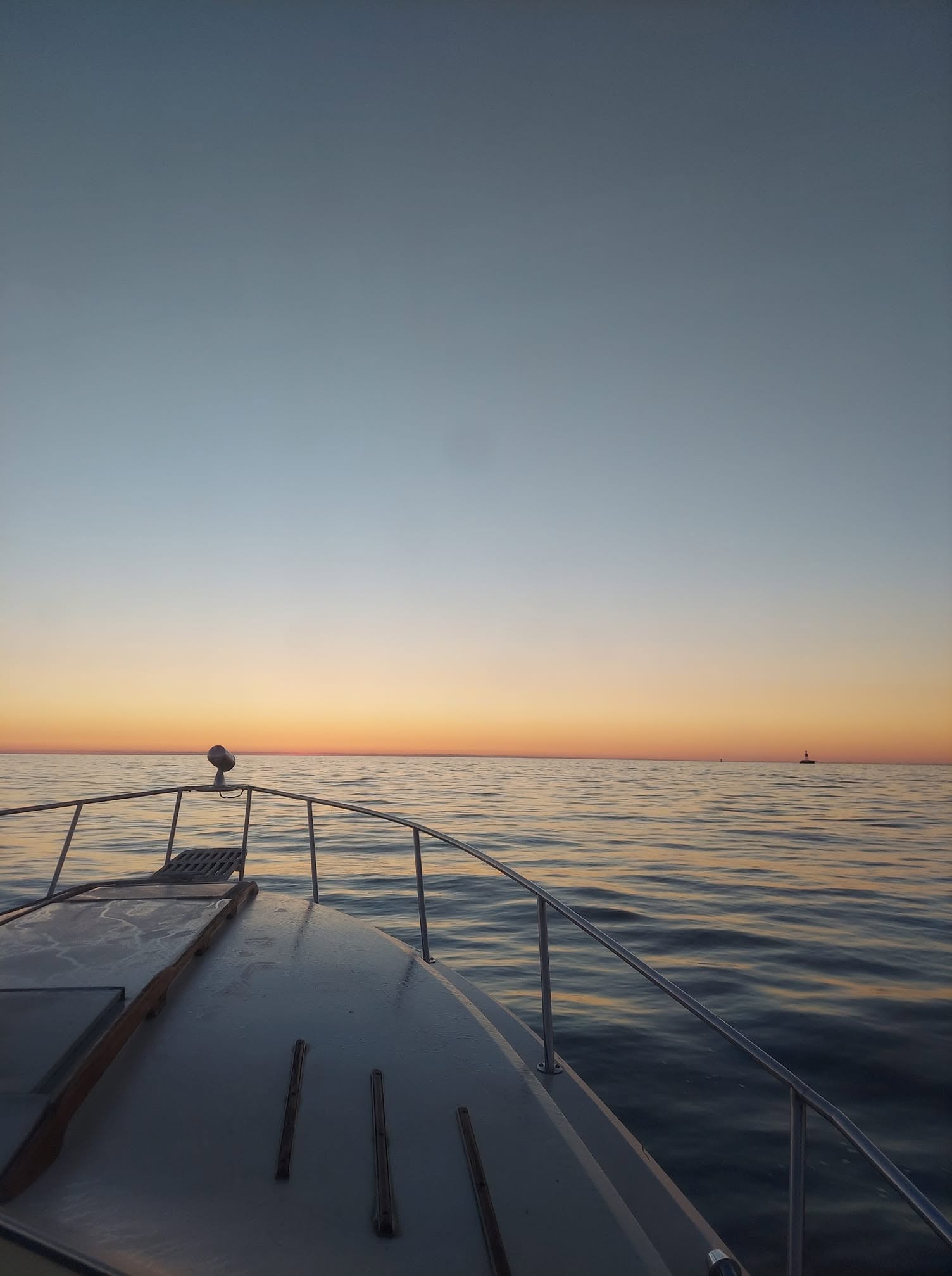 Bow of boat on calm water at sunset near Racine WI