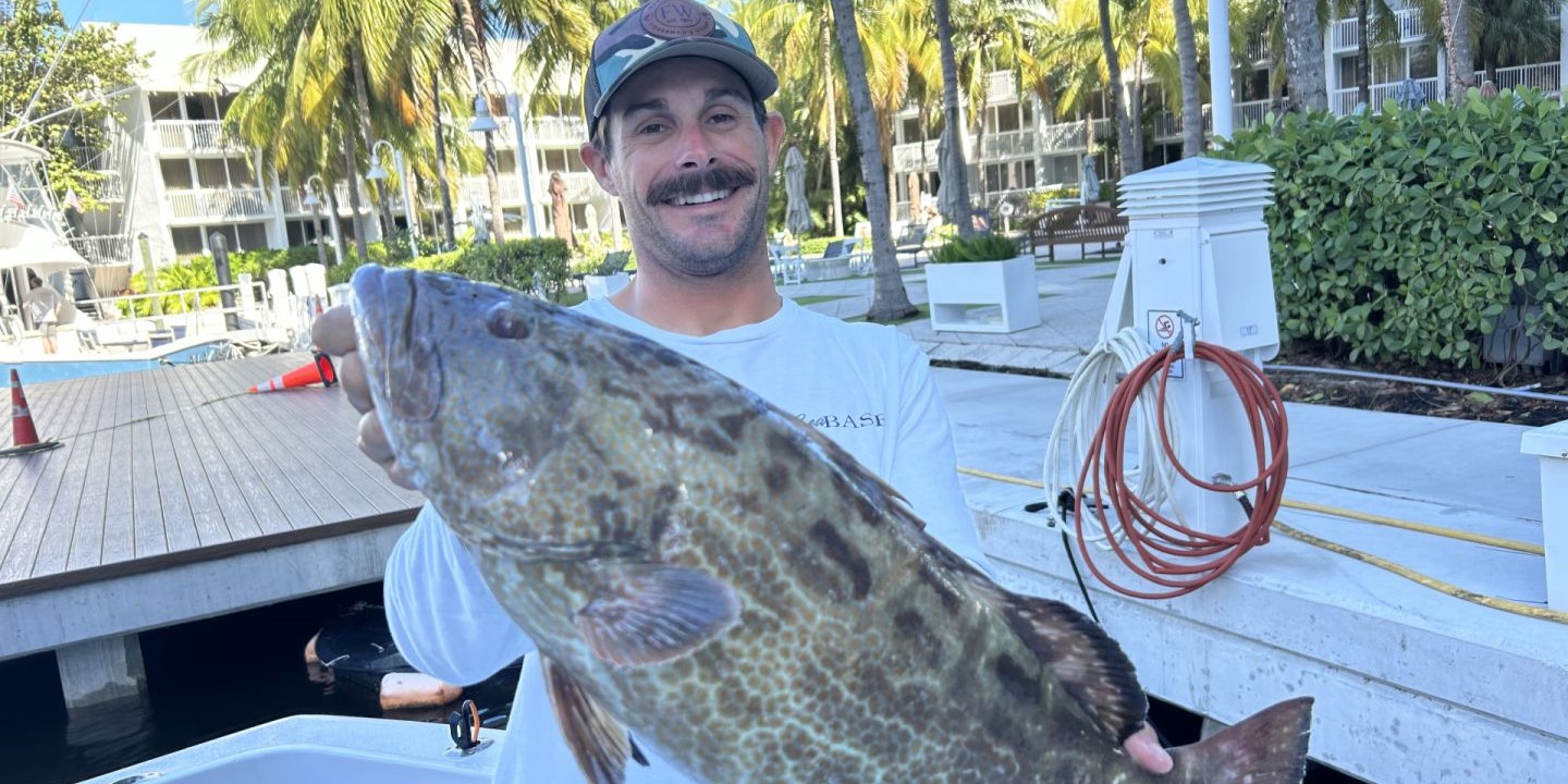 A gag grouper being held by one person in Fort Lauderdale
