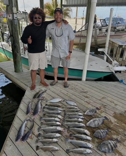 Fishing catch displayed on dock in Slidell LA with boats in marina background