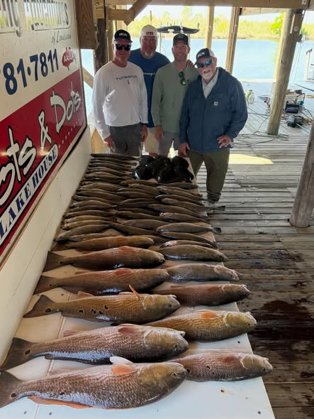 Fishing charter displaying catch of multiple redfish on dock in Slidell Louisiana
