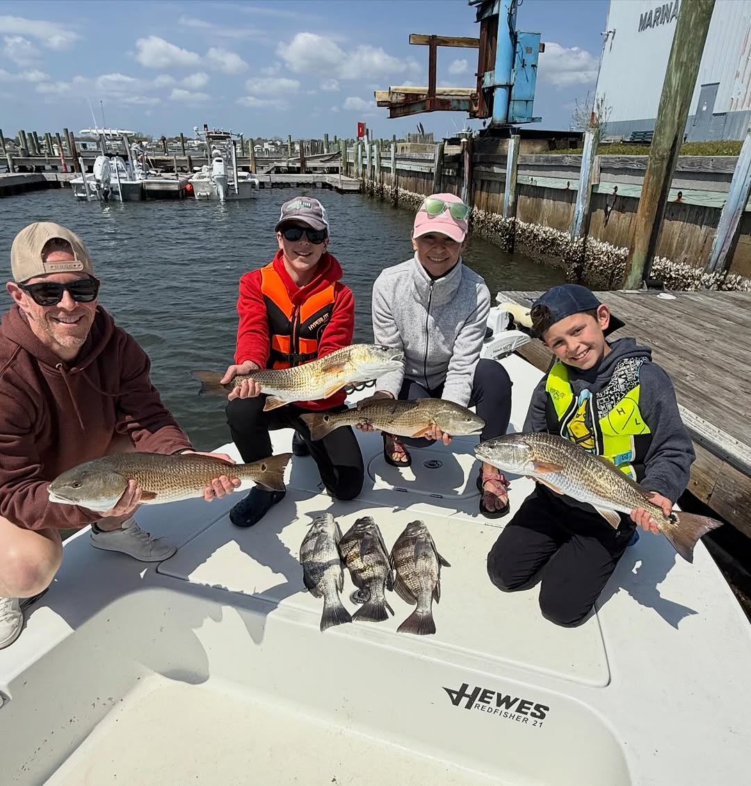 Successful fishing trip at Cedar Point NC showing redfish and black drum catch on boat deck at marina