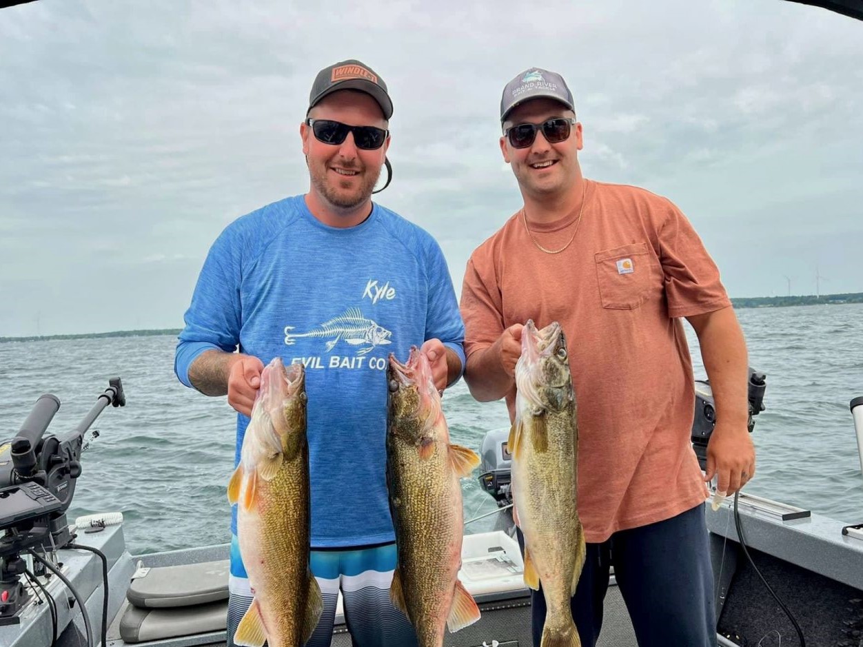 Two anglers holding three large walleye at South Cayuga.