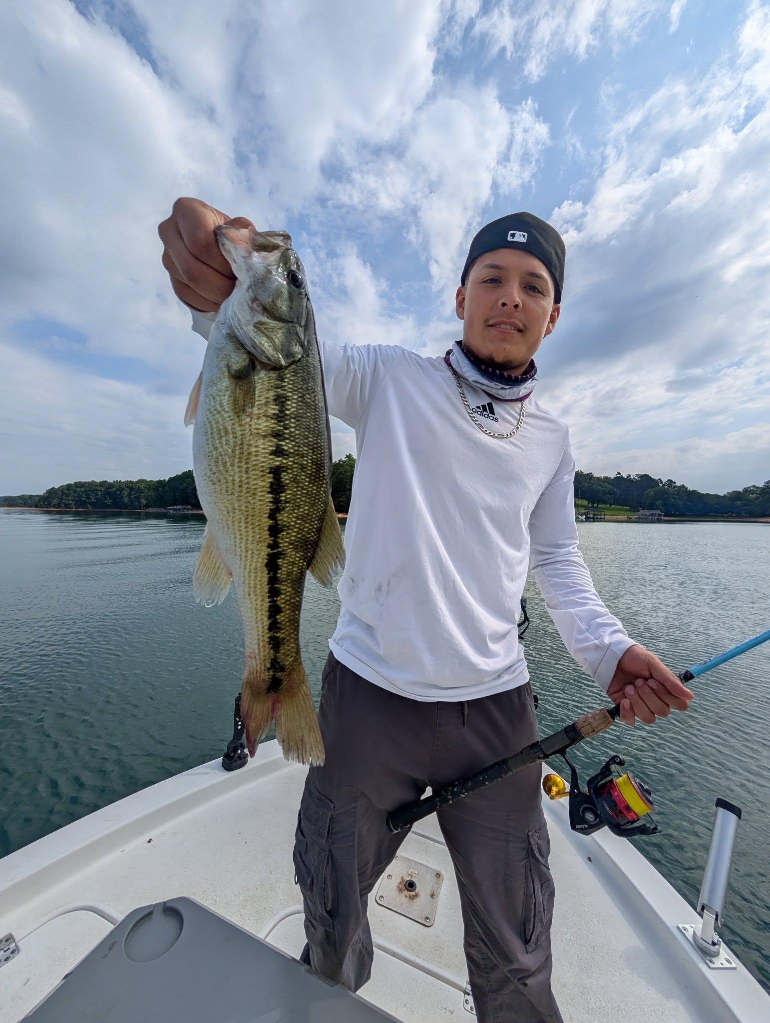 Angler holding caught bass on fishing boat in Gainesville GA lake