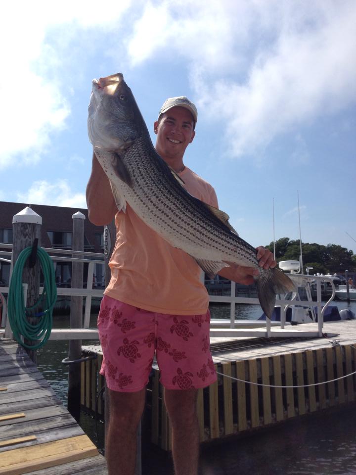 A fisherman holding a large fish in NY