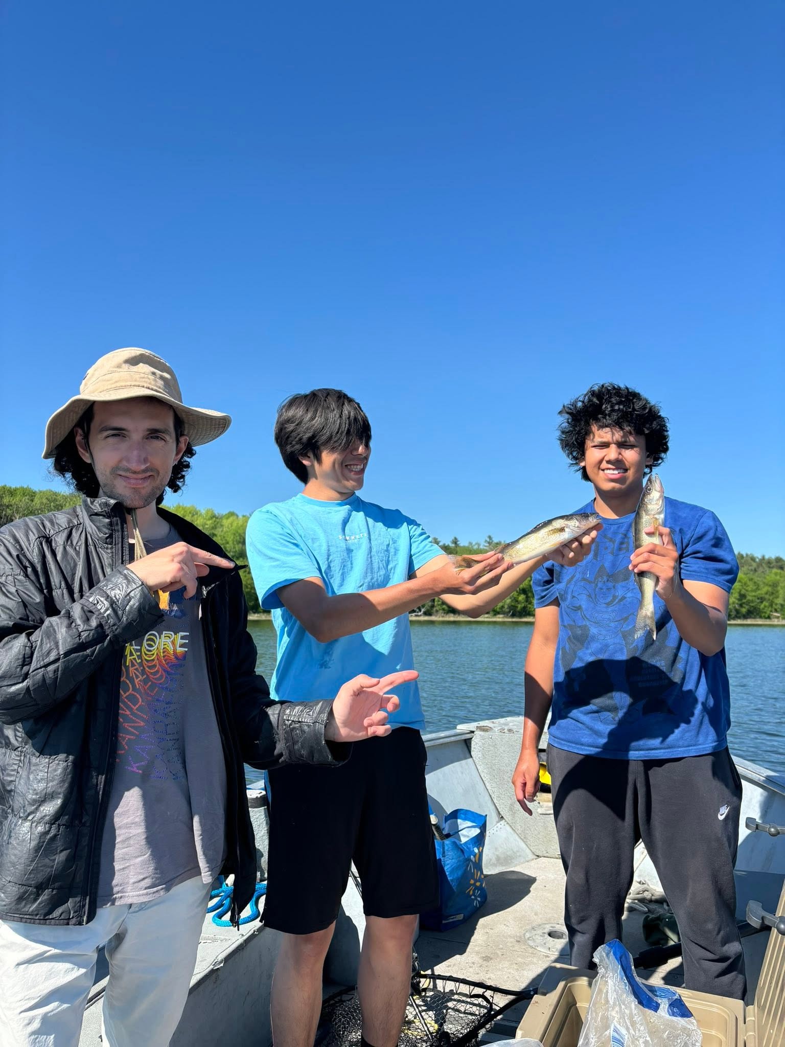 Three anglers on boat displaying freshly caught walleye in Nestor Falls ON