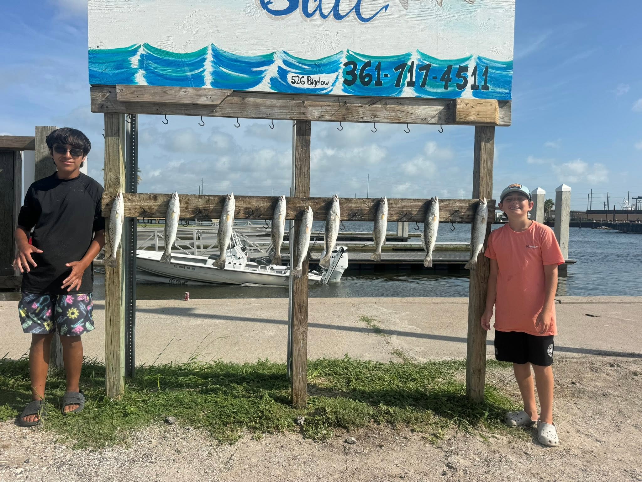 Speckled trout fishing success at Aransas Pass TX with multiple fish displayed on cleaning station