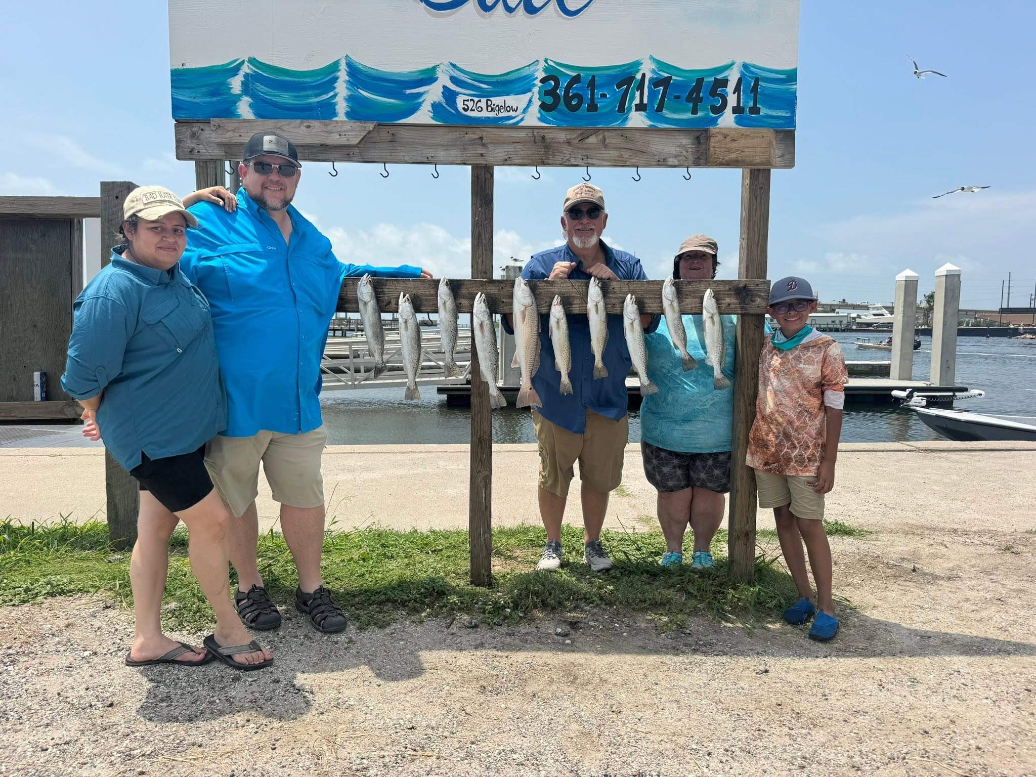 Fishing charter displaying catch of speckled trout and redfish at cleaning station in Aransas Pass TX
