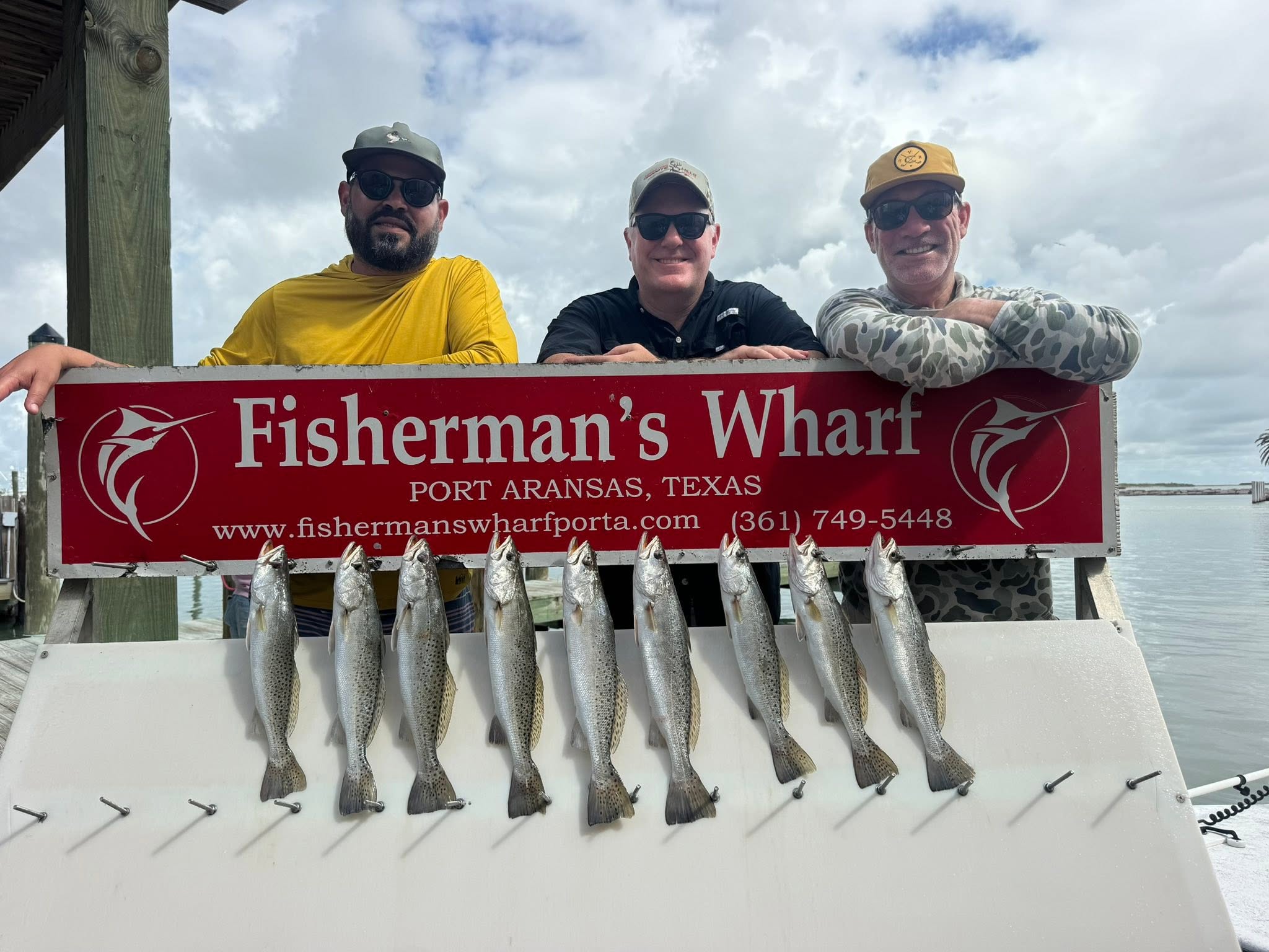 Nine speckled trout lined up on fishing boat deck at Fisherman's Wharf in Port Aransas Texas