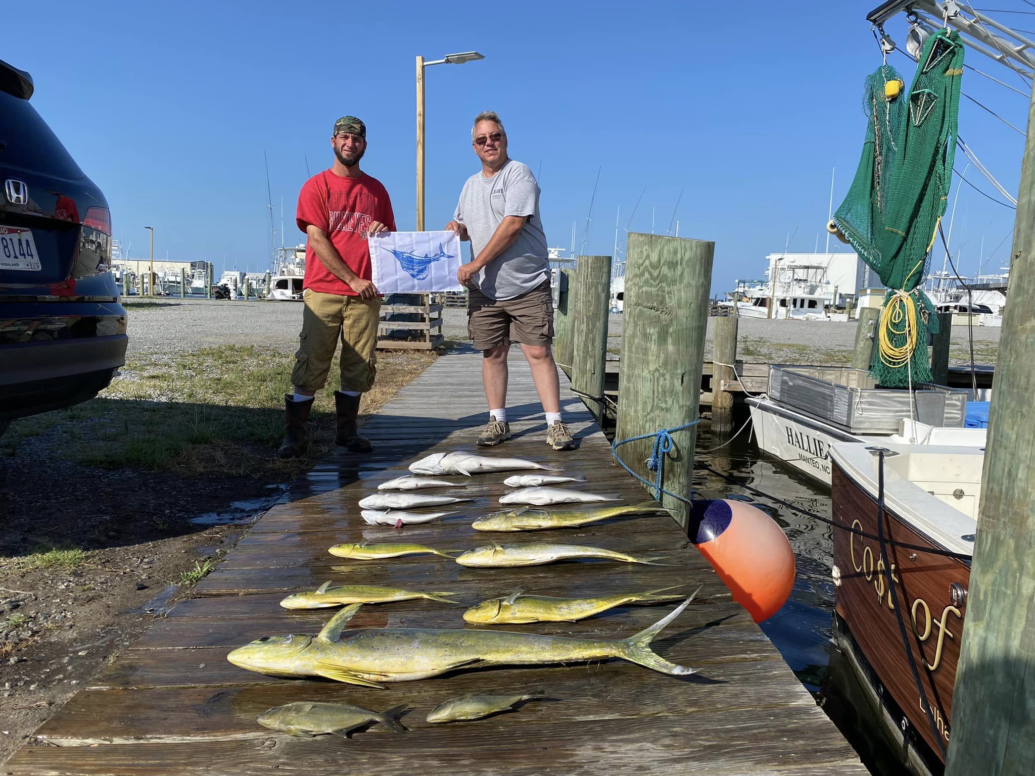 Two anglers holding a large greater amberjack fish in Wanchese