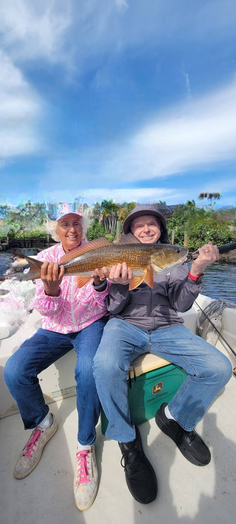 Two anglers holding a large redfish caught while fishing in Bonita Springs, Florida