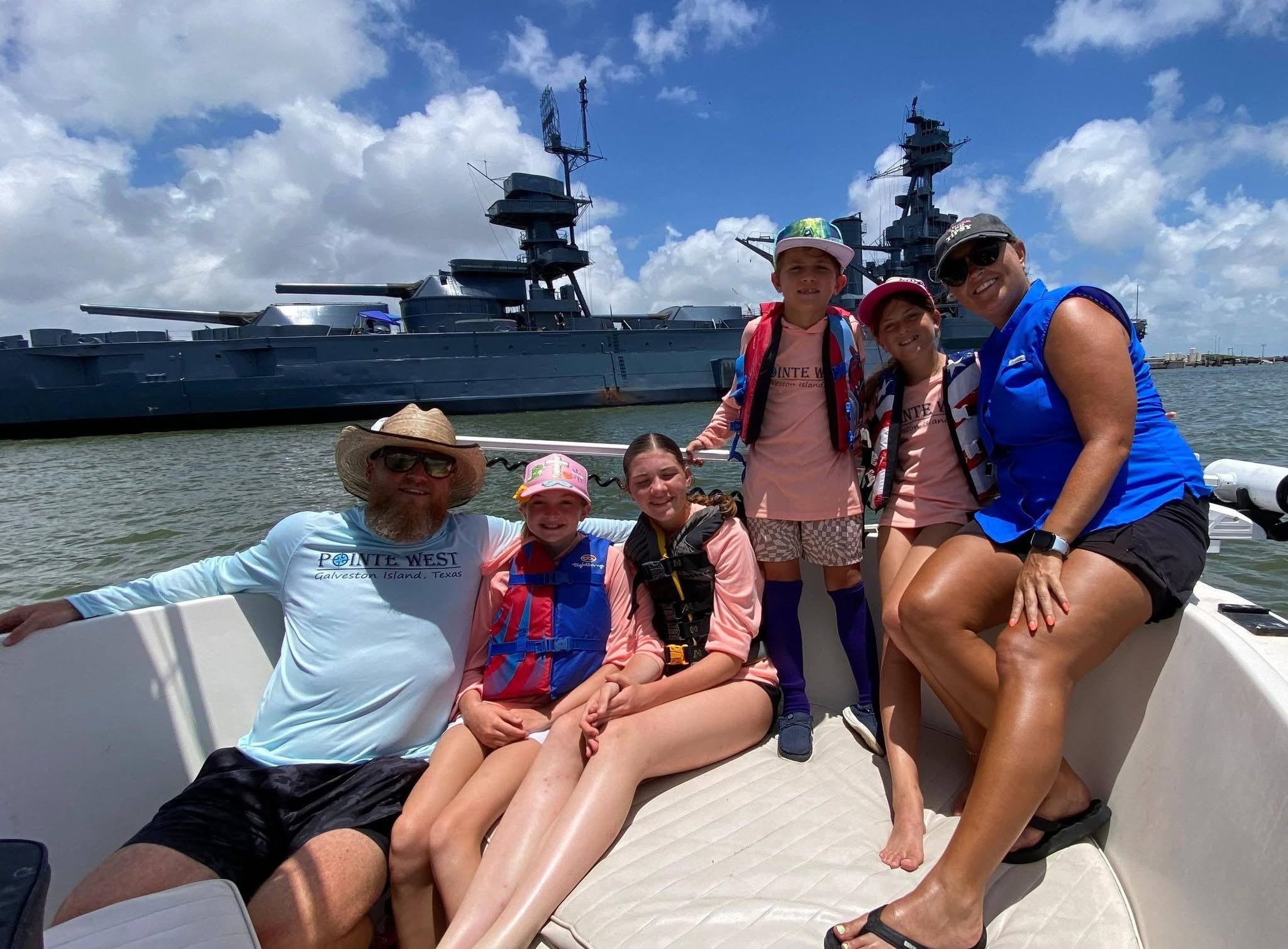 Fishing group on boat near historic battleship in Galveston TX waters