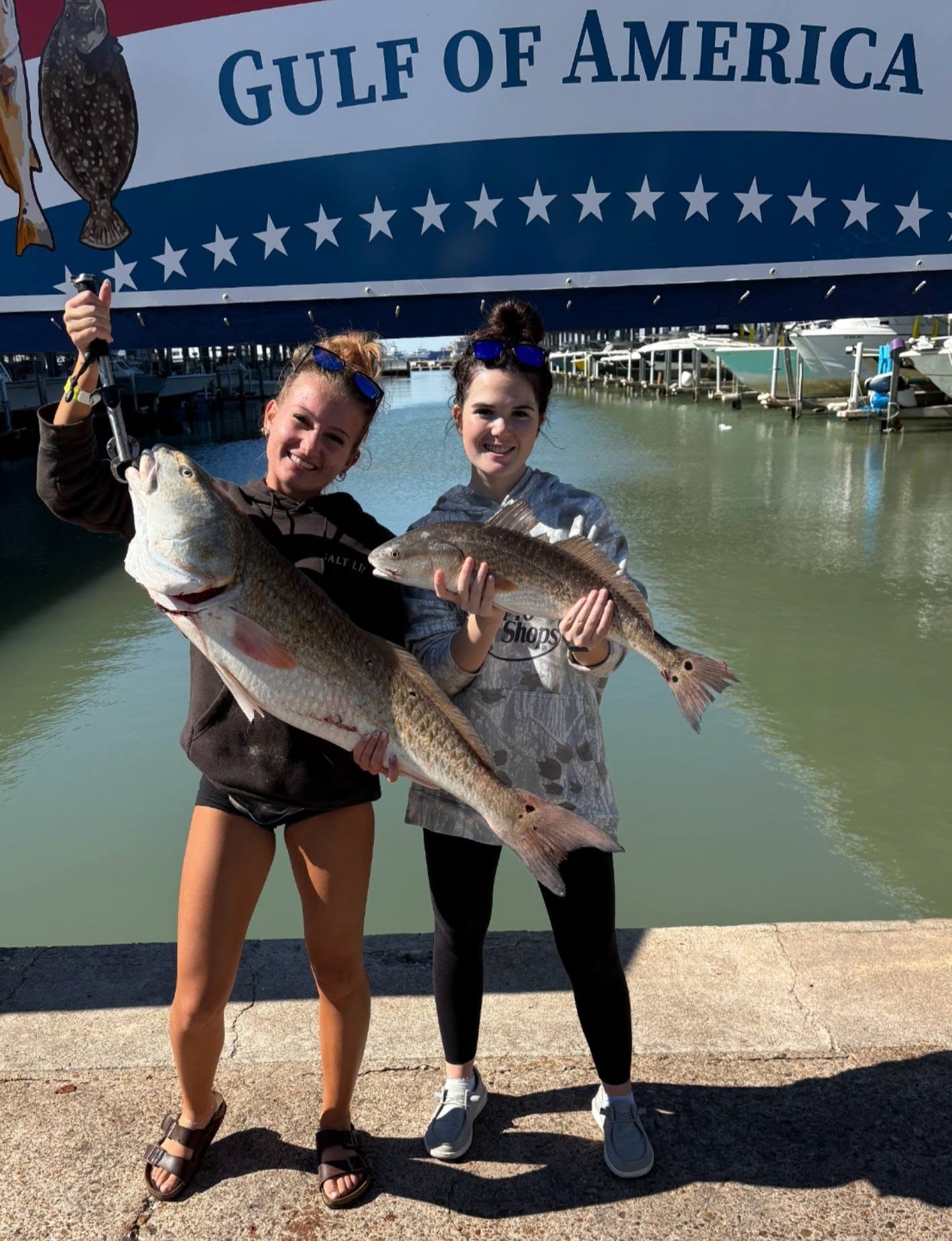 Two anglers displaying freshly caught redfish and southern flounder on fishing charter boat in Galveston TX