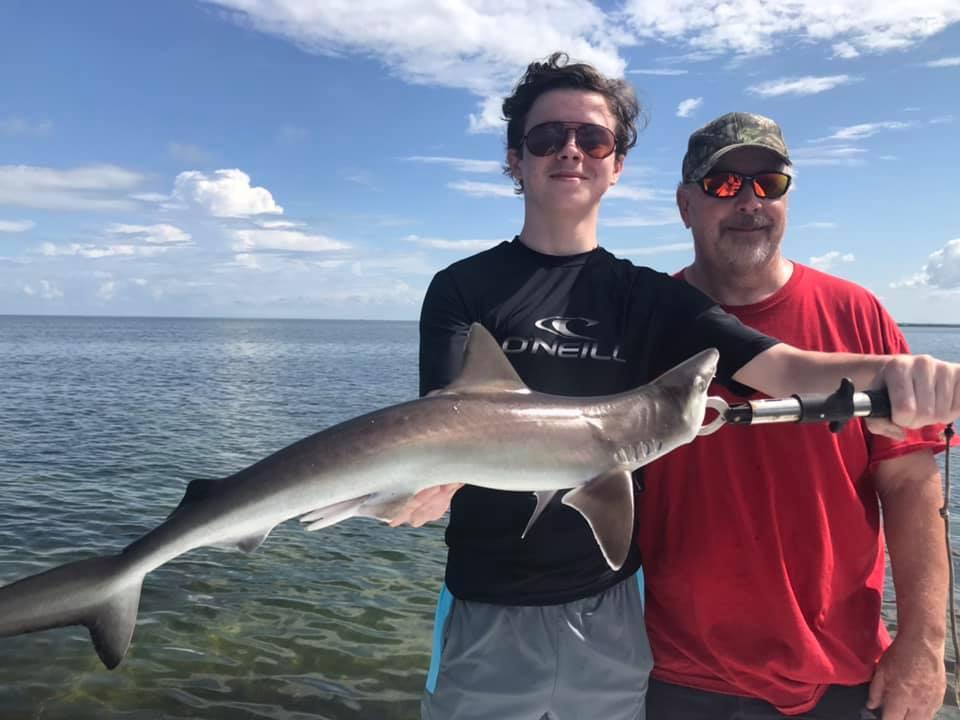 A fisherman and a person enjoying a fishing trip at Hernando Beach