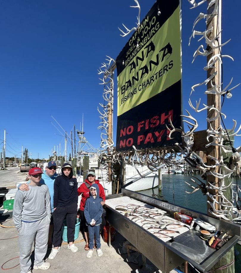 Fishing charter boat with antlers display and catch laid out on cleaning table at Marathon FL marina
