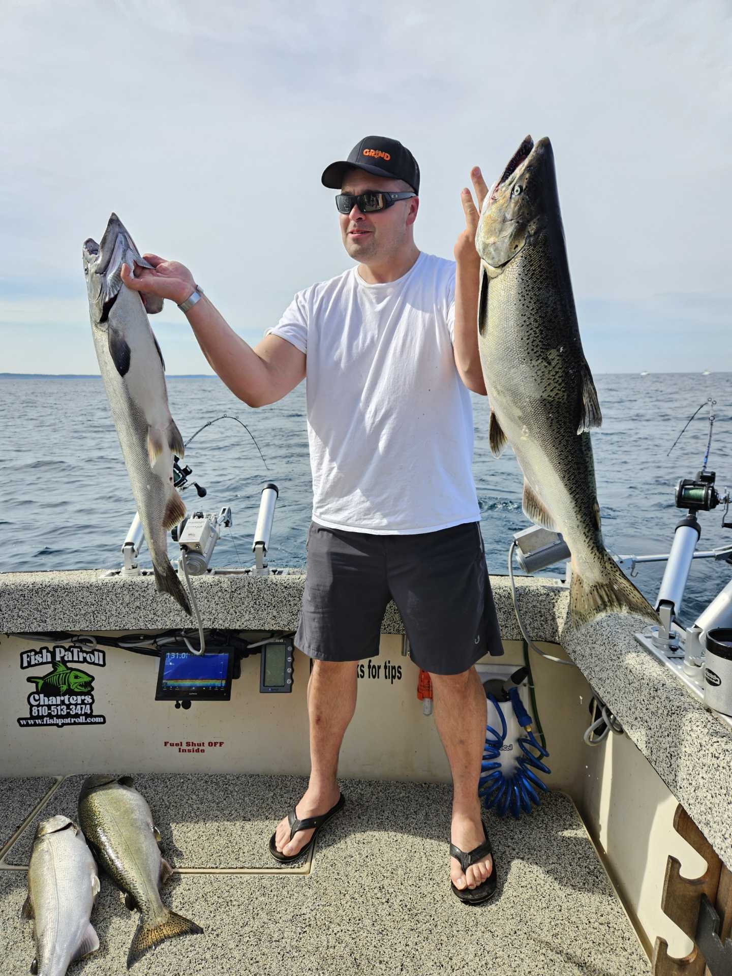 Fishing charter displaying catch of Chinook and Coho salmon on boat deck in Manistee MI