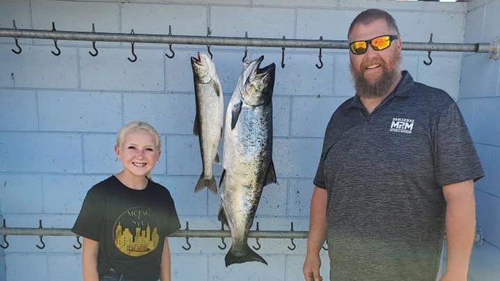 Two anglers fishing in WI with 25-inch fish