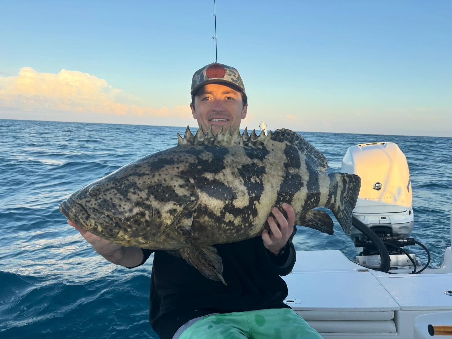 Angler holding large Goliath Grouper on fishing boat in Virginia Beach VA waters