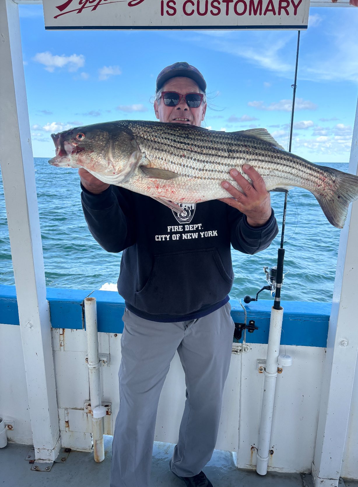 A person fishing for a striped bass in MA